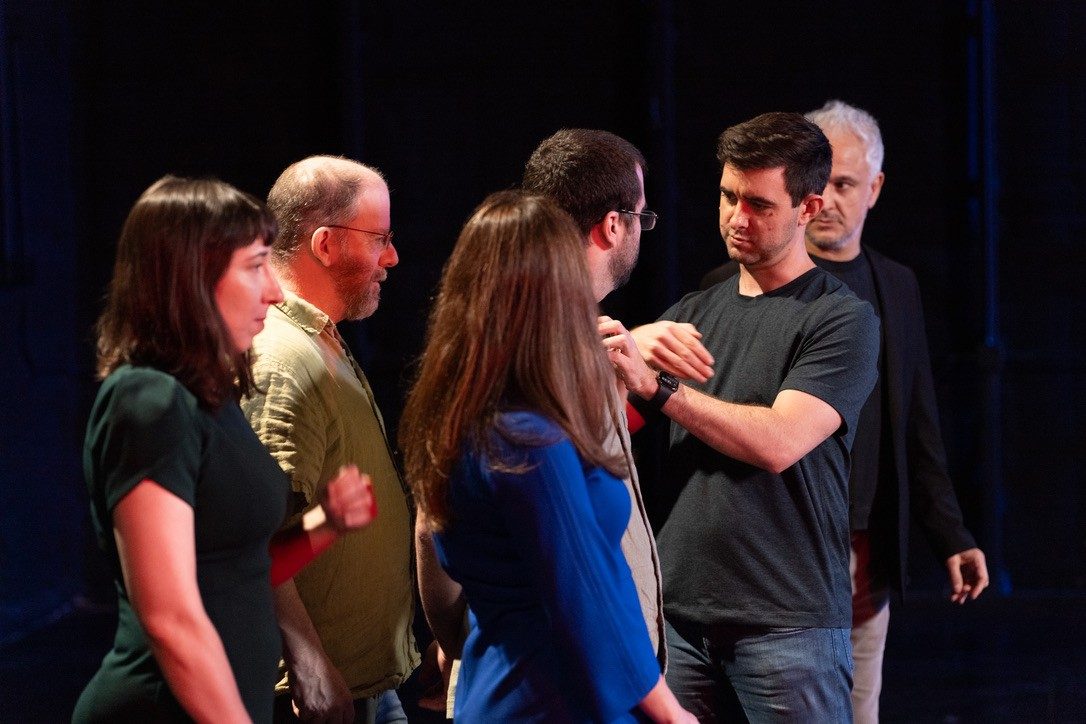 Reid adjusting a microphone on a participant before a session in Budapest while Peter Boghossian looks on